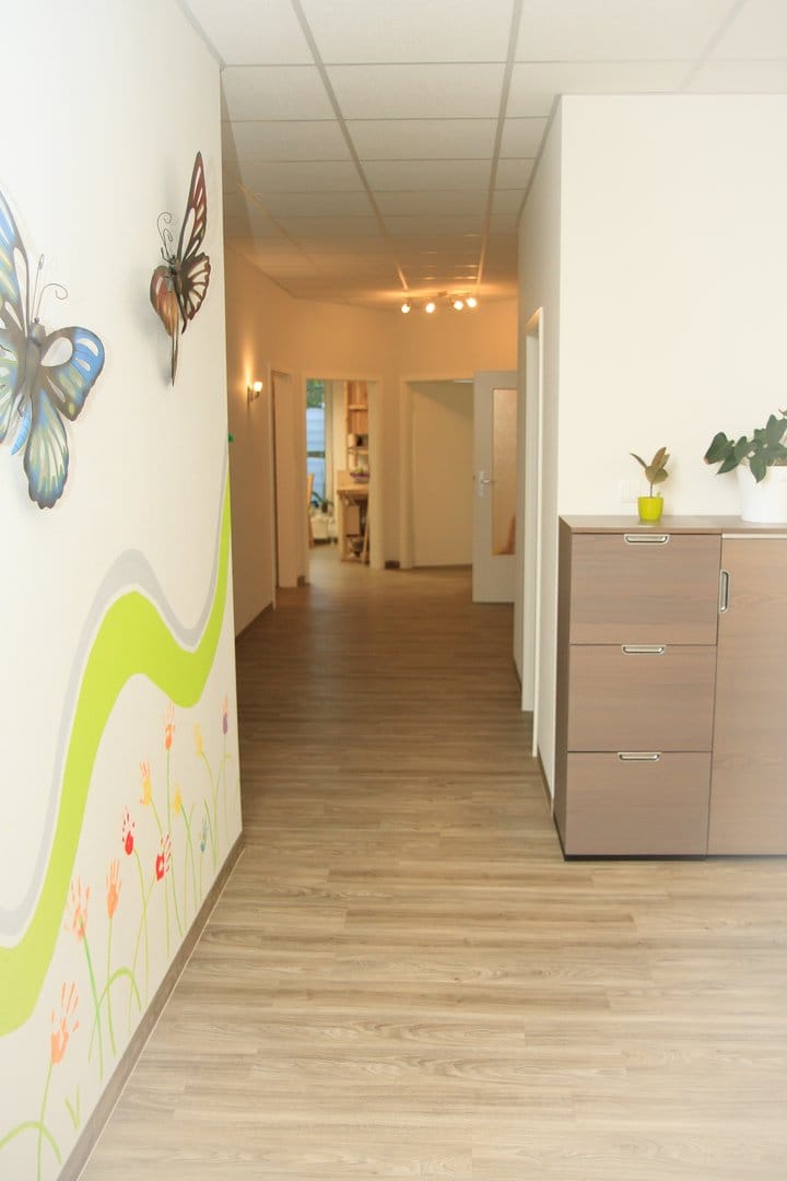 Flur der Ergotherapiepraxis mit farbiger Wandgestaltung
